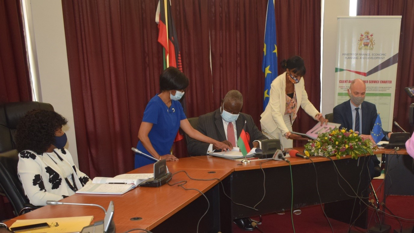  Hon. Felix Mlusu on behalf of the GoM and Ivo Hoefkens on behalf of the EU sign the Zantchito Programme as Hon. Vera Kamtuluke, Deputy Minister of Labour (L) looks on